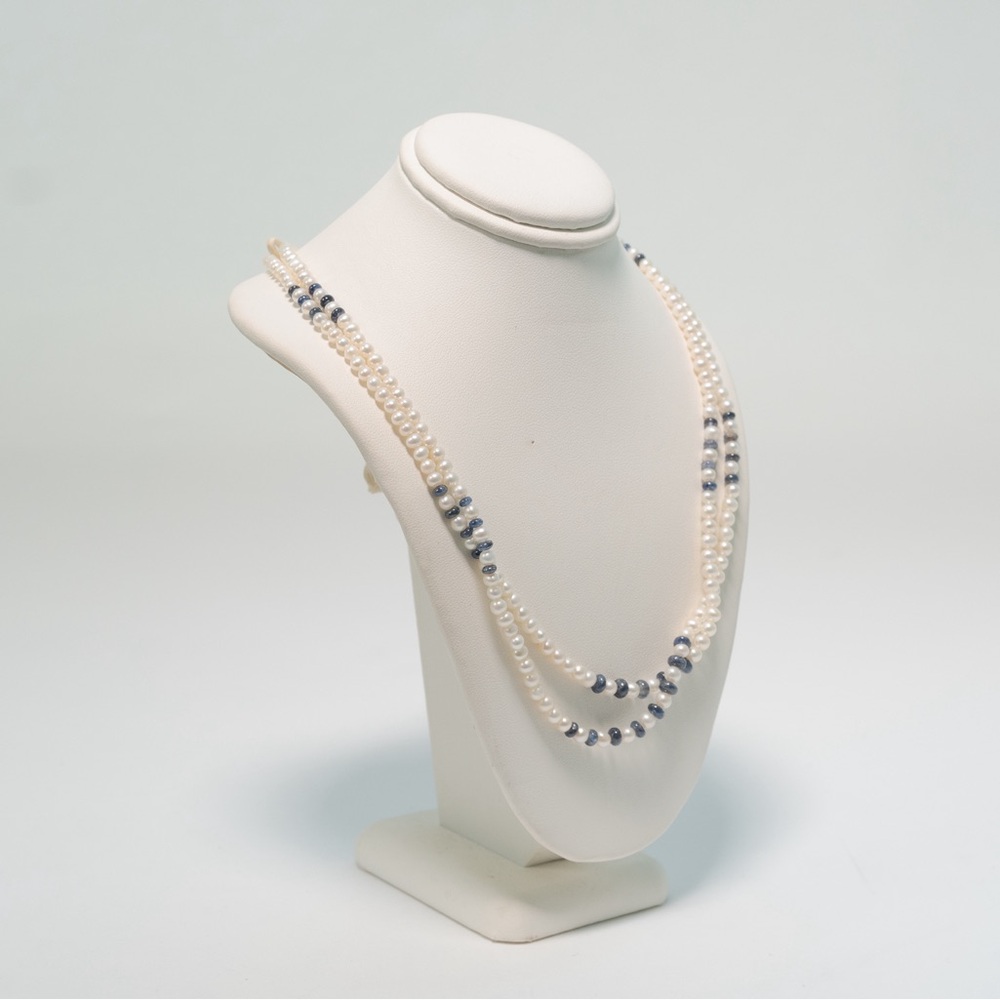 Double string pearl necklace with sapphire beads .